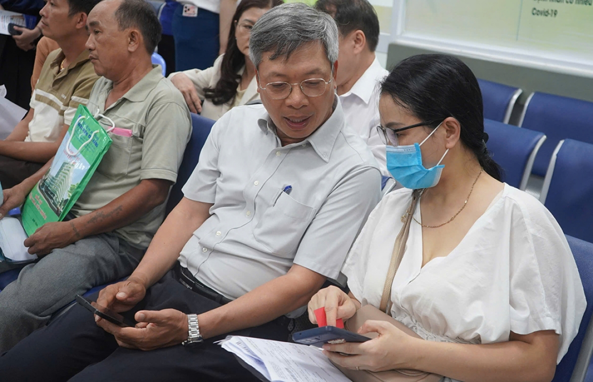 Lãnh đạo UBND thành phố hỏi thăm người dân khi đăng ký khám bệnh qua ứng dụng One-care tại Bệnh viện Đà Nẵng.