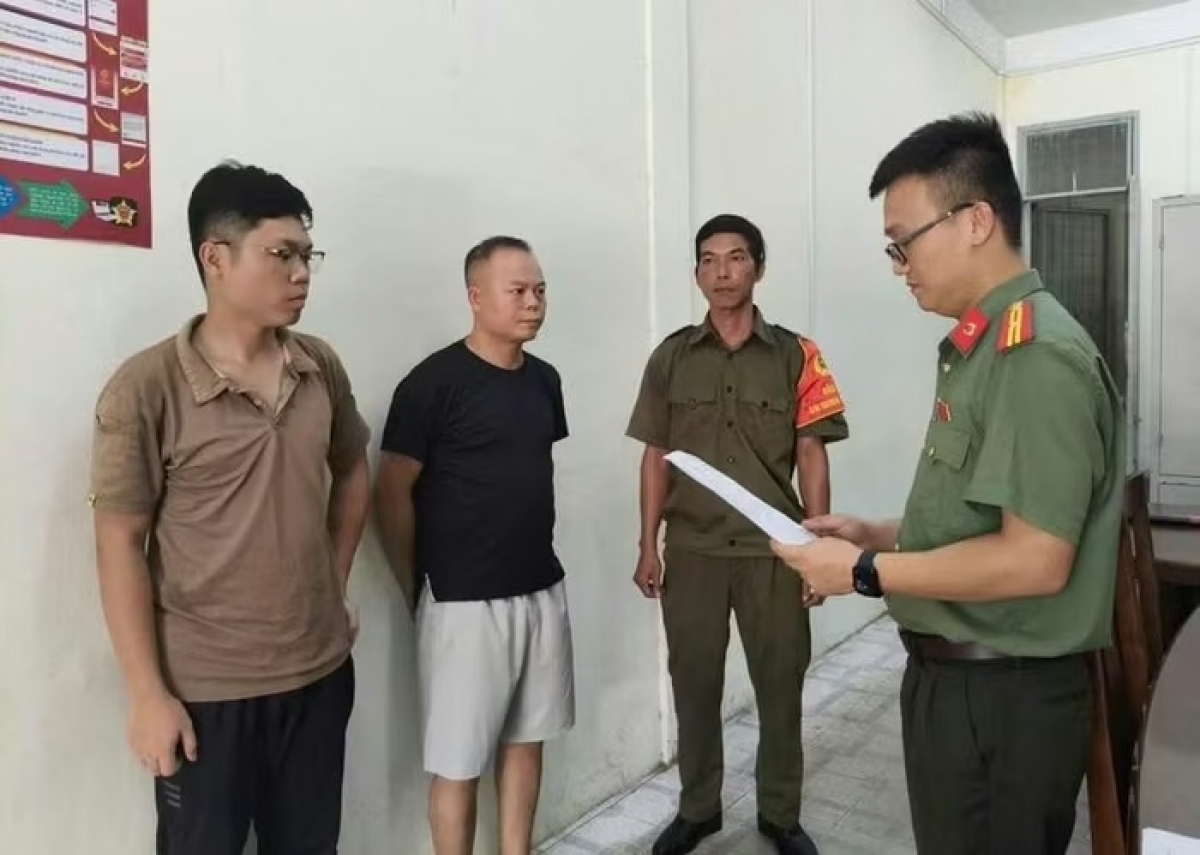 Cơ quan An ninh điều tra Công an thành phố Đà Nẵng tống đạt các quyết định đối với Chu Đức Anh (áo đen) và Nguyễn Trung Hiếu (ngoài cùng bên trái). (Ảnh: Công an cung cấp)