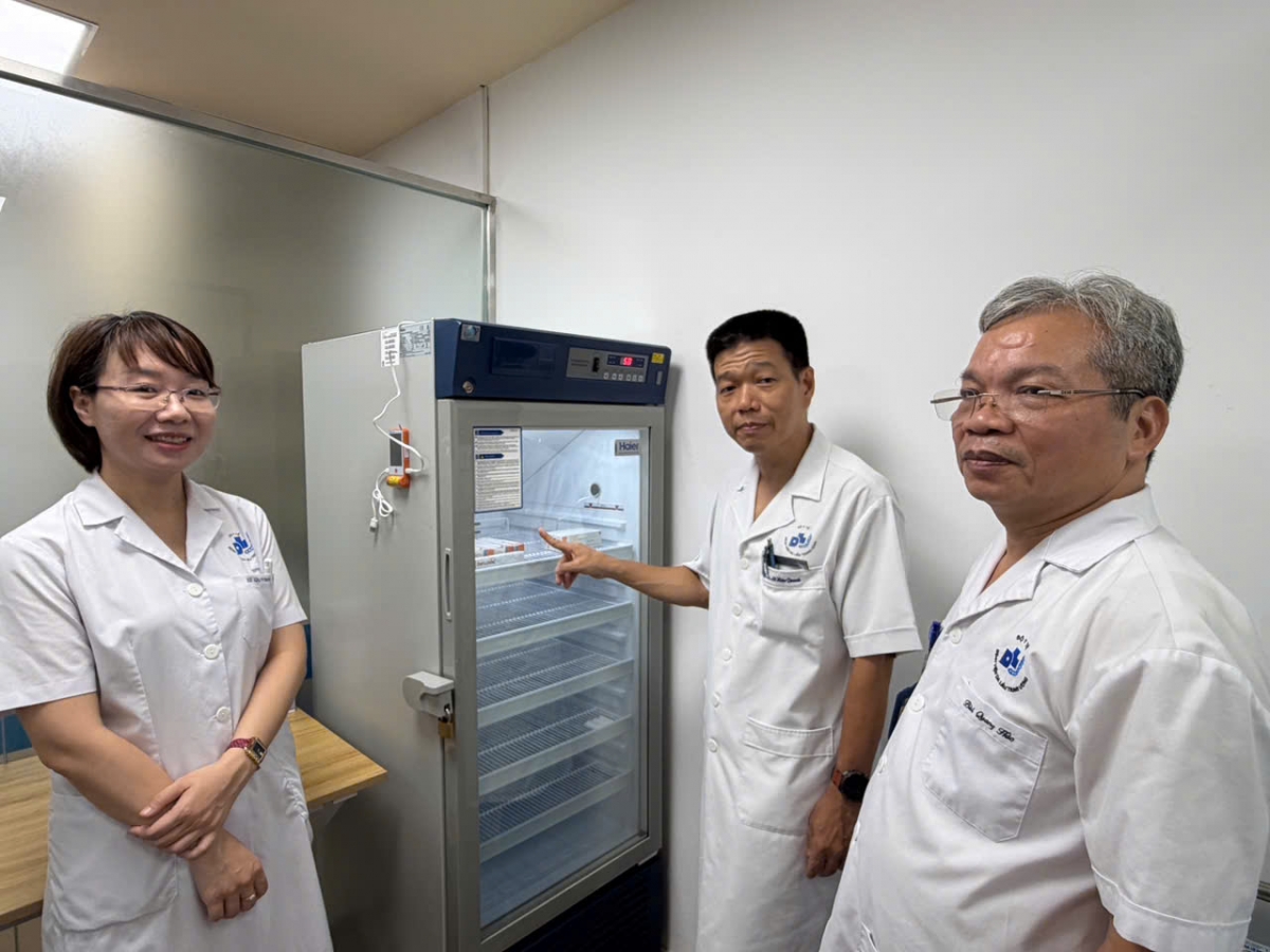 PGS.TS Lê Hữu Doanh (đứng giữa) cùng các cán bộ kiểm tra tủ bảo quản vắc xin tại Phòng tiêm chủng Bệnh viện