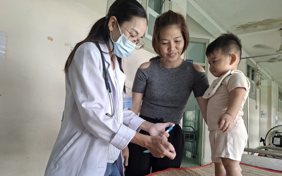 BS. Dương thăm khám cho bệnh nhi mắc tay chân miệng ở Bệnh viện Nhi đồng 2. Ảnh: Kim Dung
