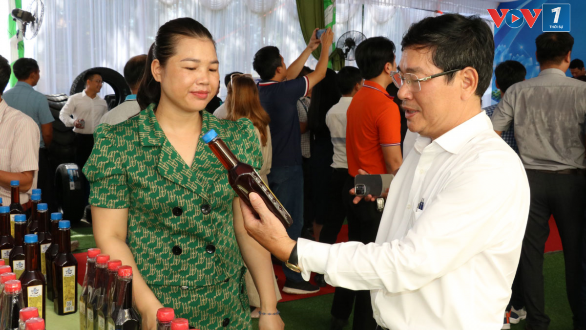 Bà Nguyễn Thị Dung, thành viên Hợp tác xã Hoàng Anh giới thiệu sản phẩm nước mắm làm từ quả điều (ảnh: Thiên Lý)